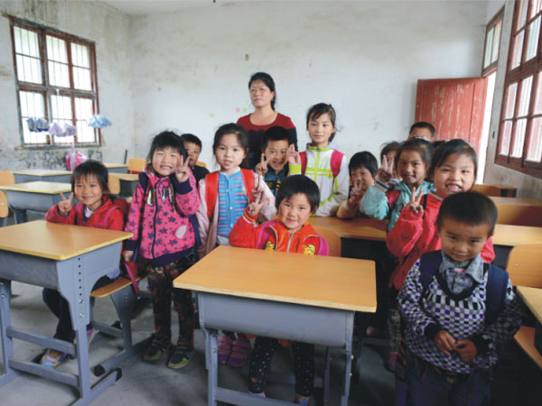 公司為一山村小學(xué)捐贈(zèng)一批課桌椅，孩子們高興地和老師一起合影